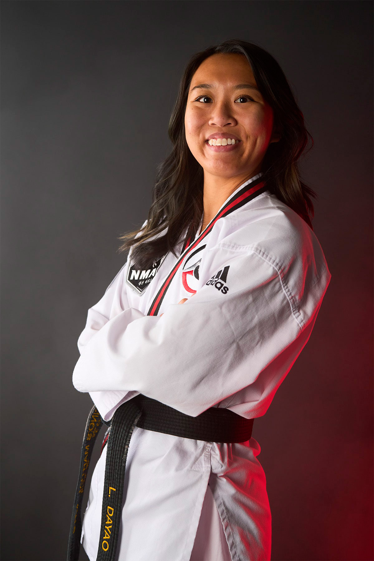 Ms. Leanne Dayao wears a white taekwondo uniform with her black belt, crossing her arms.